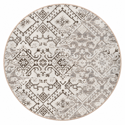 Afterimage area rug: a round area rug with a distressed geometric and tribal pattern in shades of gray, beige, and brown on a light cream background.
