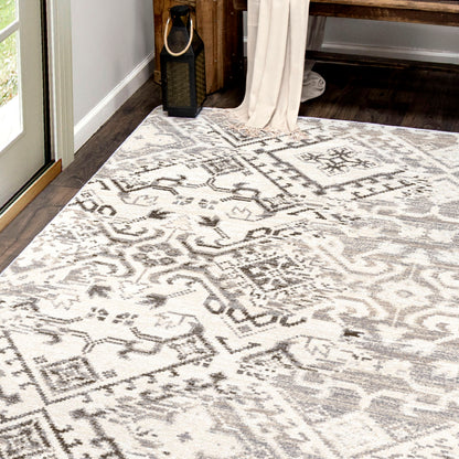 Afterimage area rug: patterned area rug on a wooden floor with a window and curtain in the background.