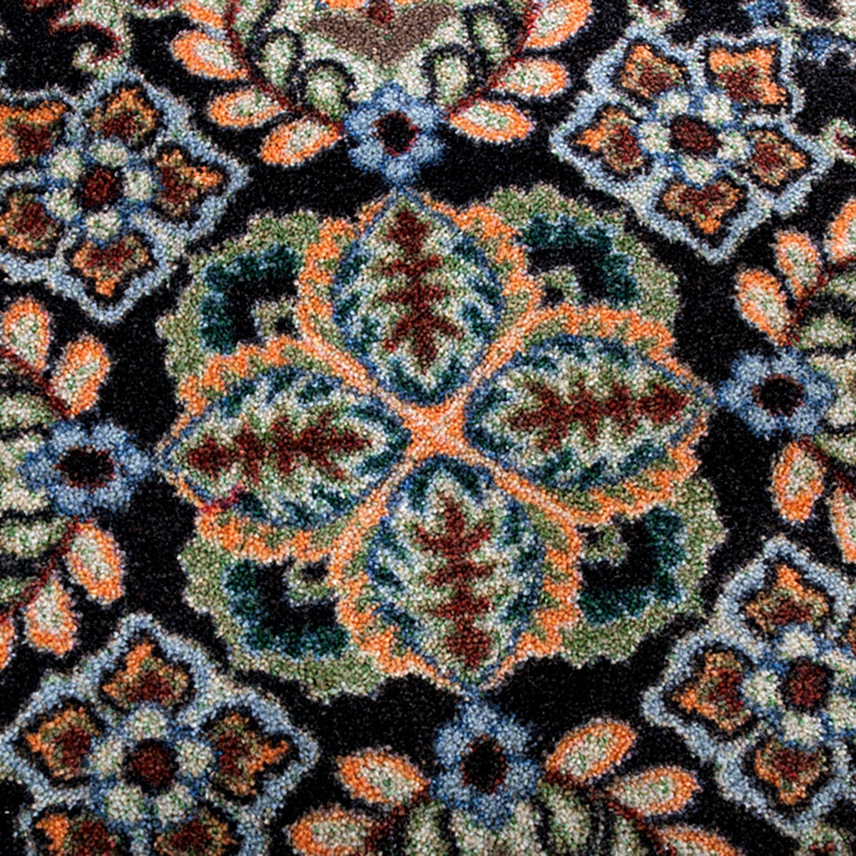 Close up ttexture shot of the Bright Side orange and blue area rug with persian inspired graphics in modern color palette nylon fibers and pet friendly and kid friendly low voc anti allergen.