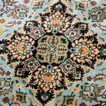 Close up of the medallion of the Bright Side orange and blue area rug with persian inspired graphics in modern color palette nylon fibers and pet friendly and kid friendly low voc anti allergen.