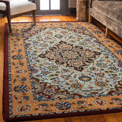 Bright Side orange and blue area rug with persian inspired graphics in modern color palette nylon fibers and pet friendly and kid friendly low voc anti allergen paired with velvet couch in sitting area.