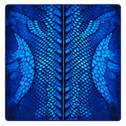 A square blue textile item, likely a pouch or small bag, featuring a symmetrical dragon scale pattern in various shades of blue and dark navy.