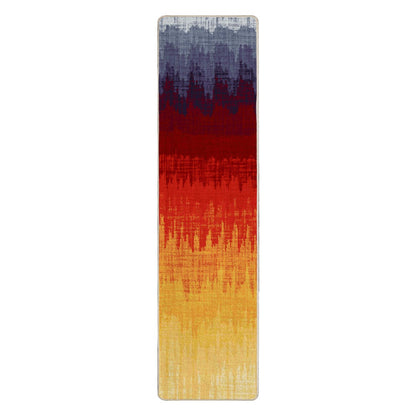 Color Wave area rug: a tall, narrow rectangular rug with an abstract ikat-style vertical gradient pattern transitioning from dark blue-gray at the top, through deep red, to bright red and golden yellow at…