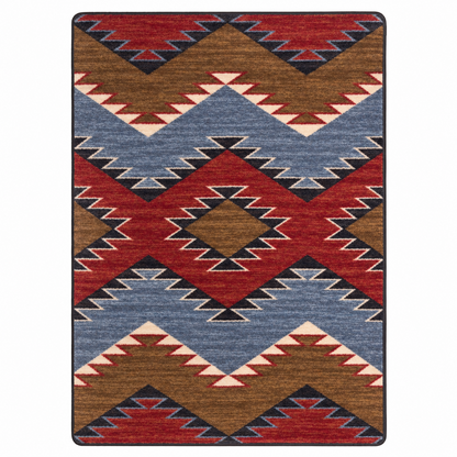 Crossplay area rug: a rectangular area rug with a Southwestern geometric pattern featuring red, brown, slate blue, black, and cream zigzags and diamonds.