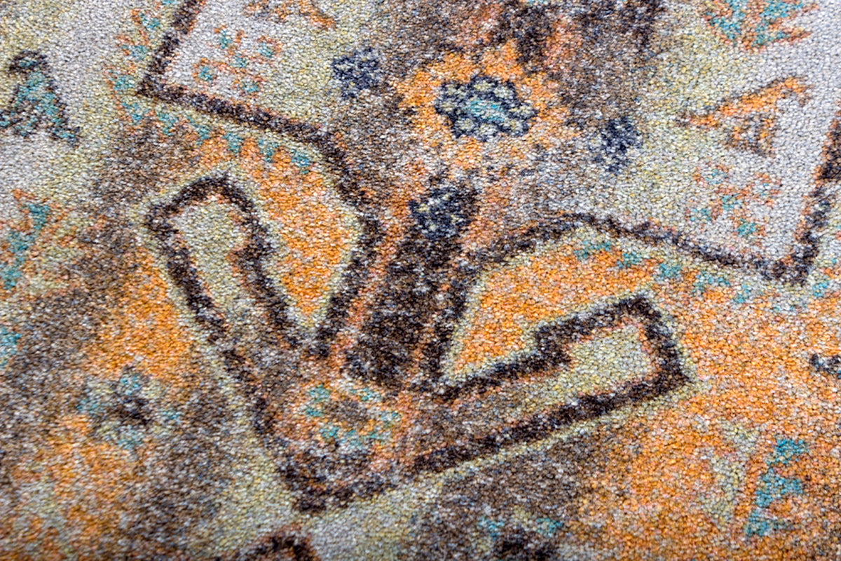 Ttexture close up of enduastran rug in shades of bright orange and brown with fleck of blue.