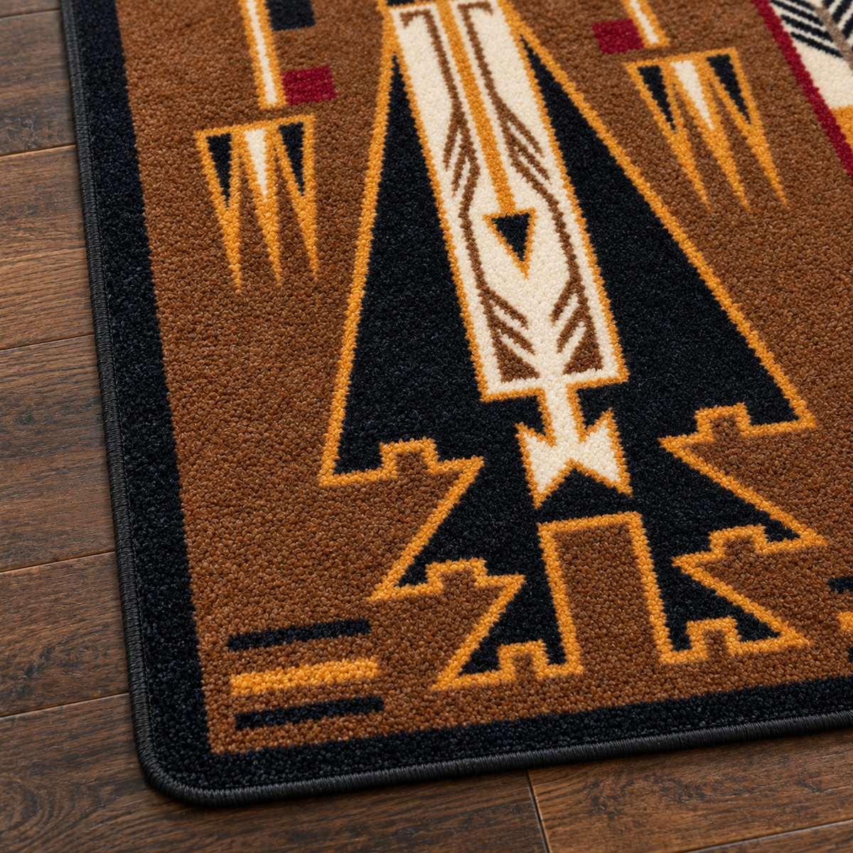 A close-up of a Southwestern-style area rug with a geometric pattern in brown, black, cream, and orange, shown on a dark wood floor.